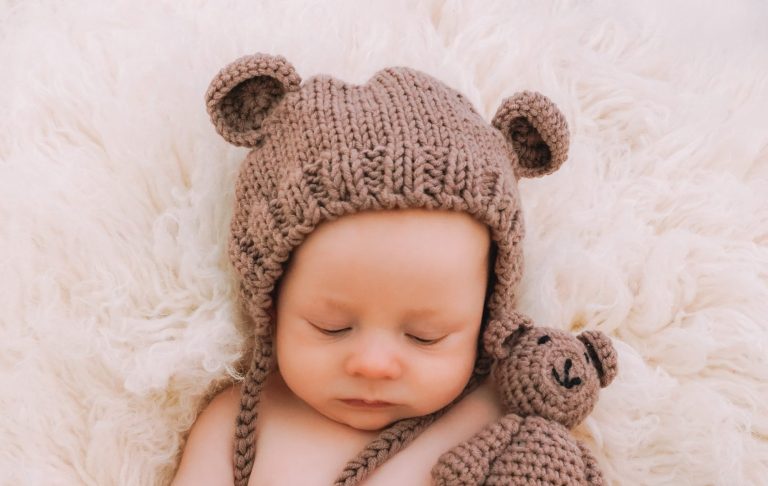 Close-up of a baby's feet resting on a soft, fluffy surface.